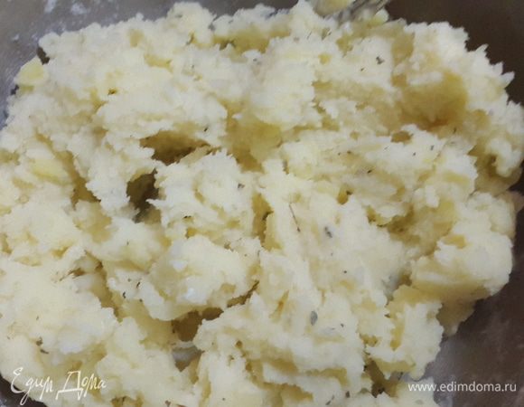 Когда картофель сварился, вынимаем лук и лаврушку, сливаем воду, но не всю, и разминаем в пюре, добавляем немного сушеного базилика, немного оливкового масла, 3 столовые ложки с горкой муки и быстро перемешиваем. Даем немного остыть.
