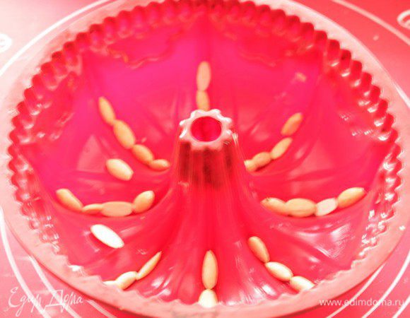 В это время залить клюкву кипятком. Очищенный миндаль выложить на дно  формы.