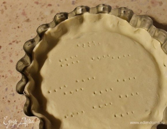 Две формочек смазать оливковым маслом. Слоеное тесто слегка раскатать, выложить в формочки, дно наколоть вилкой.