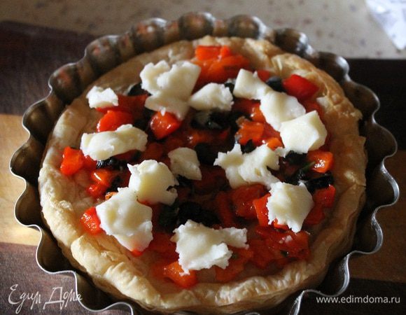 Вынимаем тарталетки из духовки, кладем начинку из перца, маслин и зелени. Сыр руками рвем на кусочки и раскладываем сверху.