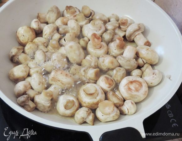 Шампиньоны выбирайте помельче, чтобы не пришлось их разрезать. И постарайтесь купить свежие белые грибочки, на вкусе это не отразится, но готовое блюдо будет красивее.
Помытые шампиньоны выкладываем на разогретую сухую сковороду, держим их там 5 минут. Огонь должен быть чуть меньше максимального. За это время они пустят сок.
