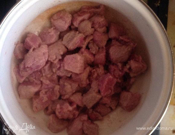 В кастрюлю влить растительное масло, выложить мясу. Обжаривать, изредко помешивая, 5-7 минут. 