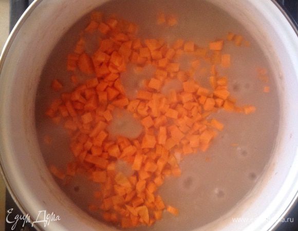 Очистить моркови и порезать кубиками. Добавить морковь в кастрюлю, перемешать, убавить огонь, накрыть крышкой и оставить тушиться 50-60 минут. В процессе тушения подливать воду.