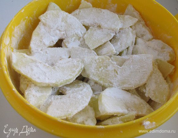 Выложить нарезанные яблоки  в глубокую посуду, добавить крахмал и перемешать.