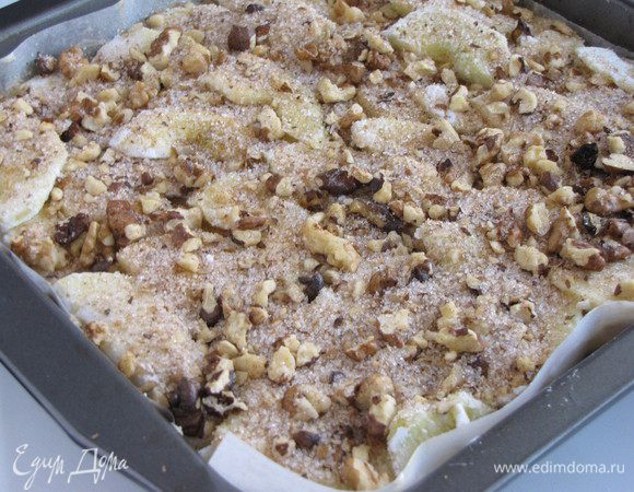 Снова покрыть всю поверхность дольками яблок. И посыпать яблоки оставшейся ореховой смесью.