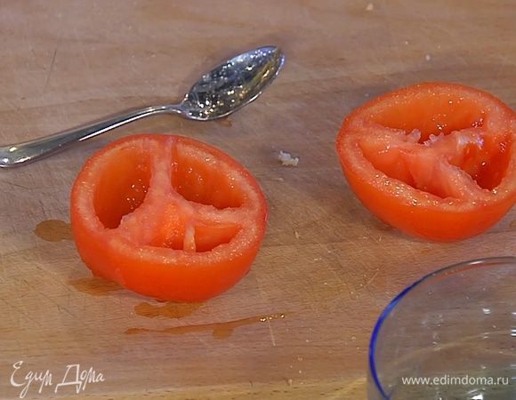 Большой помидор разрезать пополам и удалить семена с соком.