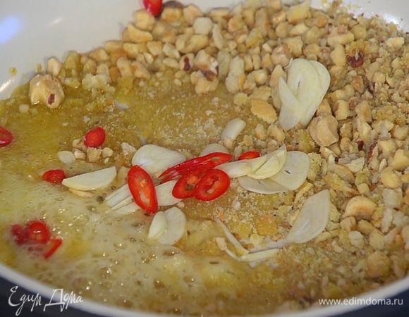 Приготовить крамбл: разогреть в сковороде оливковое и сливочное масло, выложить измельченные сухари и орехи, добавить чеснок и перец чили, все перемешать и обжарить.