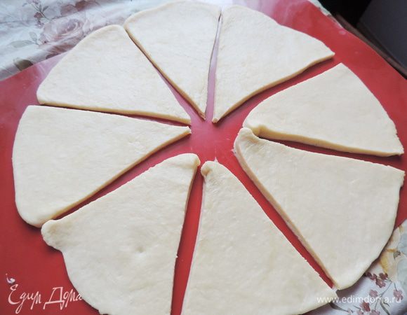 Час прошел незаметно. Готовое тесто делим на пять частей. Работаем по очереди с каждой частью. Раскатываем ее в круг диаметром 30 см, разрезаем его на 8 секторов.