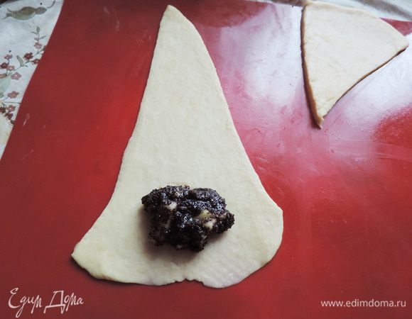Каждый сектор я еще немного раскатываю, чтобы удлинить его. Возле широкой части кладем полную чайную ложку начинки.