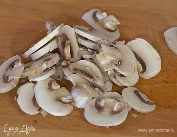 Шампиньоны нарезать тонкими пластинками, добавить в сковороду с луком, посолить, поперчить и перемешать.