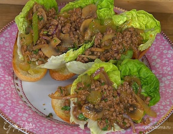 На обжаренный хлеб поместить салатные листья, сверху выложить фарш с овощами.