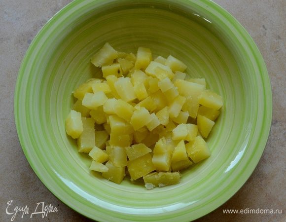 Предварительно подготовить картофель. Его можно очистить от кожуры, нарезать небольшими кубиками и отварить на пару. А можно отварить в "мундире", а после уже очистить и нарезать. Выложить подготовленный картофель в миску.