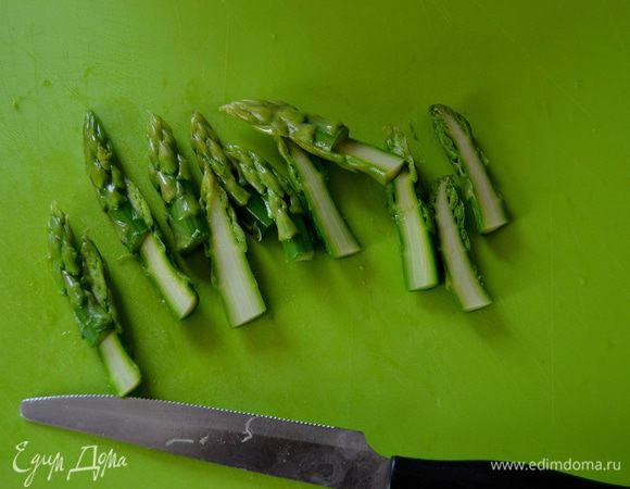 Отложенные предварительно верхушки спаржи разрезать вдоль пополам. 