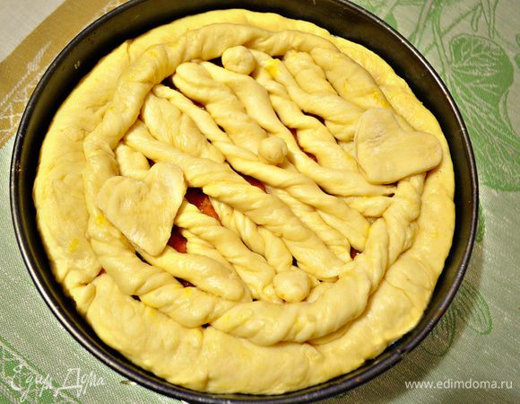 Из оставшегося теста сплести косички или жгуты. Выложить по краю формы и в виде сеточки сверху пирога. Накрыть полотенцем и дать постоять в тёплом месте 30 мин.