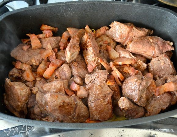 Затем добавляем к овощам мясо и бекон. Посолить, поперчить и присыпать мукой. Как следует перемешать и дать всему содержимому обжариться еще пару-тройку минут.