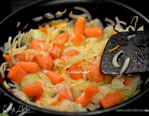 На другой сковороде растопить 30 г сливочного масла. Выложить порезанную крупную луковицу тонко и крупно порезанную морковь. Тушить 15 мин, помешивая.