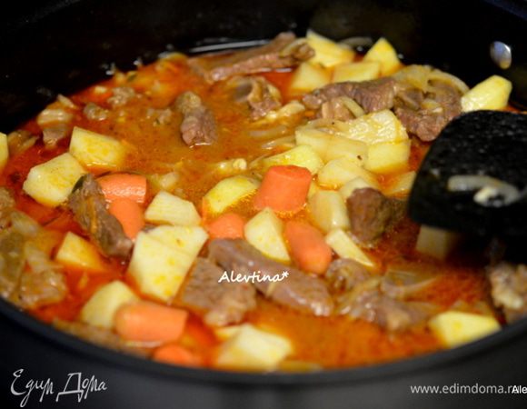 Через пройденный час добавить в общее блюдо, переложить морковь и лук, очищенный и порезанный кубиками картофель. Закрыть крышкой и тушить 30 мин.
