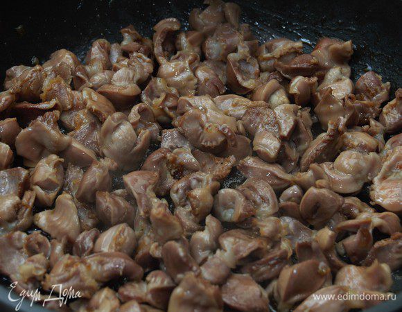 В сковороду добавить желудки, помешивать и на сильном огне обжарить в течении 3-х минут.