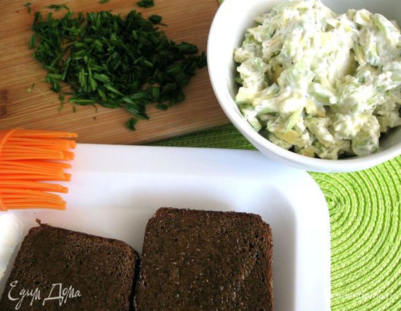 У кильки удалить голову и шкурку. Вчерашний хлеб хорошо поджарить на решетке в духовке (сковороде, СВЧ). Корку натереть чесноком. Удобно это делать, если срезать часть зубчика чеснока. Оливковое масло нанести кисточкой на плоскую часть хлеба. Оставшийся чеснок пропустить через пресс, добавить к смеси, перемешать.