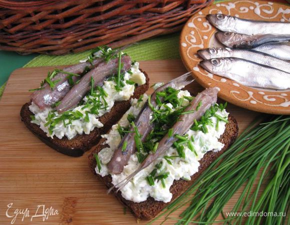 Нанести на хлеб смесь, обсыпать луком, сверху положить по 2 кильки. Приятного аппетита!
