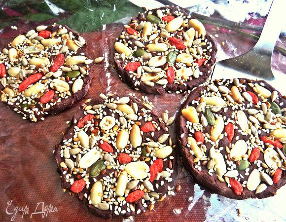 Тогда я снова проделала все манипуляции (благо плитка была 200 г): растопила 100 г шоколада на водяной бане и размазала вот такими медальонами уже на смазанной маслом без запаха (для страховки) плёнке на доске. Насыпала орешки-семечки-ягодки... Убрала в морозилку.