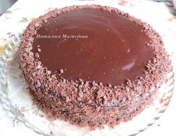 Торт вынимаем из формы, проводим ножом вдоль ее борта, а затем аккуратно открываем кольцо.
Торт щедро поливаем глазурью. Можно это сделать в два этапа. Я просто медленно выливала глазурь в центр торта и давала ей самостоятельно растечься.
Убираем торт в холодильник. Перед подачей ему следует постоять минимум ночь. Но автор рецепта рекомендовала его вообще готовить за сутки. Я готовила торт вечером, а следующим днем мы его ели.
Оформляем торт по своему вкусу. Я посыпала бока трюфельной крошкой.