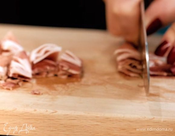 Мелко нарезать бекон, отправить в кастрюлю к луку. Продолжать пассеровку.