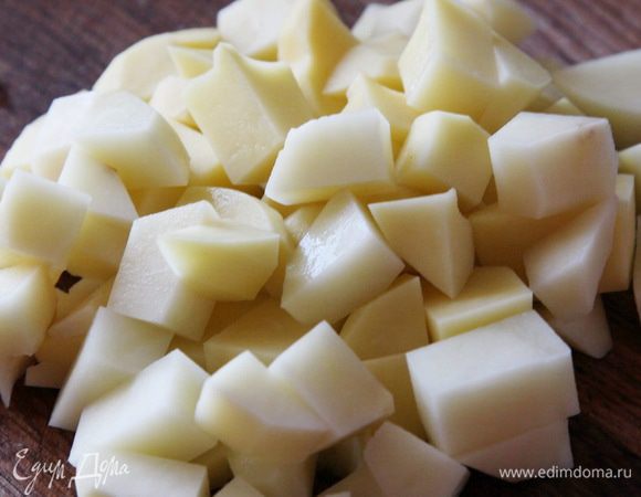 4 средних картофелины чистим, моем и нарезаем кубиком. Отправляем в кастрюльку и готовим минут 15.