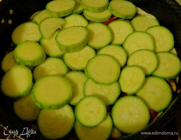 На полуготовую зажарку нарезать кружками кабачки. Посолить, поперчить.