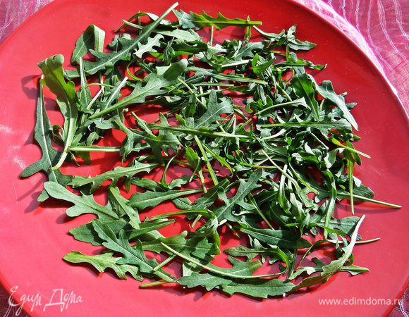 Рукколу покупаем уже чистую и разбрасываем по дну большого блюда.