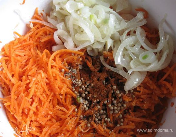 К моркови добавить уксус и специи: жгучий красный перец, красный сладкий перец, черный свежемолотый перец, зиру, кориандр, перемешать. Добавить репчатый лук с чесноком и всем тем растительным маслом, на котором жарился лук.