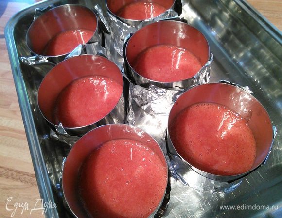 Из фольги сделайте донышки для сервировочных колец и поставьте их на удобный поддон. Разведите желатин в 2 ст л воды, дайте набухнуть, подогрейте  (я поставила на самую малую мощность в микроволновку на 7 мин), размешайте, чтобы он полностью растворился и смешайте с сорбе. Т. к.  клубника у меня из холодильника, то смесь тут же начинает желироваться.  Наполните кольца сорбе в равном количестве и поставьте их  в морозилку. 