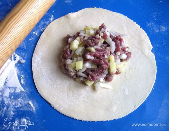 После раскатки круга из теста, положить начинку, отступив от края.