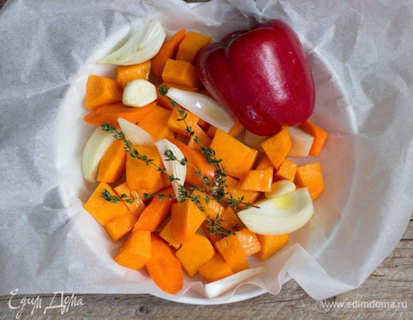 Морковь и тыкву нарезать средними дольками. Лук очистить и нарезать не слишком мелко, зубчики чеснока очистить и оставить целыми или раздавить ножом. Перец оставляем целым, так его будет легче освободить от кожицы после запекания. Сложить овощи в форму для запекания, сбрызнуть оливковым маслом, сверху выложить свежий тимьян. Отправить в духовку, предварительно разогретую до 180 градусов.