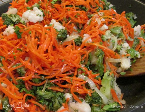 Затем добавить цветную капусту и брокколи (одно соцветие оставить для украшения), морковь и мелко рубленную зелень. Посолить, поперчить. Влить  воды, чтобы капуста не жарилась, а тушилась. Готовить 15 минут.