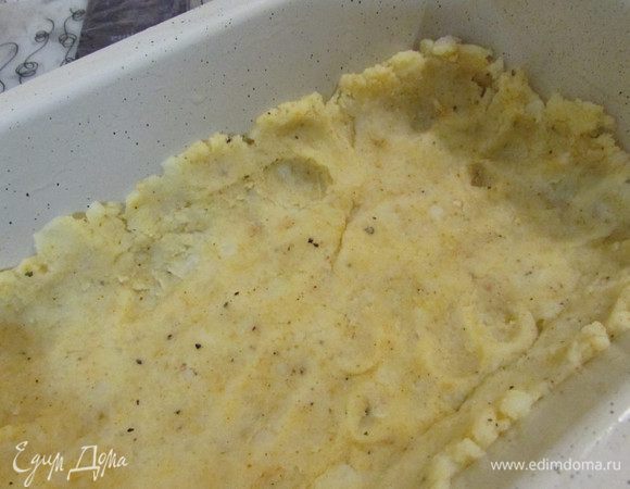 Форму для запекания смазать растительным маслом. Выложить часть картофеля.