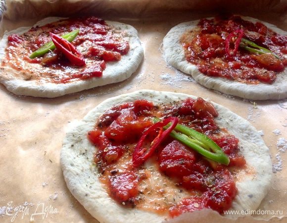 Застелить противень пергаментной бумагой, НЕ смазанной маслом, а посыпанной слегка мукой, выложить туда лепешки, каждую намазать томатным соусом, еще сверху присыпать немного сухим базиликом и для украшения перцем чили (вам НЕ советую им украшать..там где он лежал получилось достаточно остро).