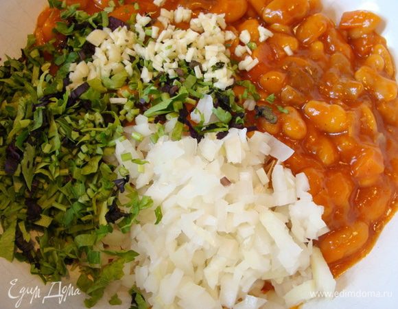 Фасоль выложить в миску. 
У меня белая фасоль с грибами в томатном соусе, можно взять и красную и конечно без грибов, но лучше, чтобы томатный соус присутствовал.
Добавить к фасоли мелко порезанный чеснок и большую часть порубленной зелени, сок из половинки лайма (можно и цедру), сметану, молотый чили. Перемешать.