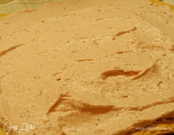 Развернуть рулет и поверхность намазать кремом. Снова свернуть в тугой рулет и убрать в холодильник для пропитки.