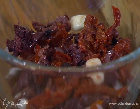 Приготовить заправку: вяленые помидоры перемешать с нарезанными оливками и чесноком.