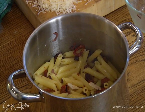 В горячие макароны выложить заправку, перемешать, затем добавить большую часть моцареллы и сыра.