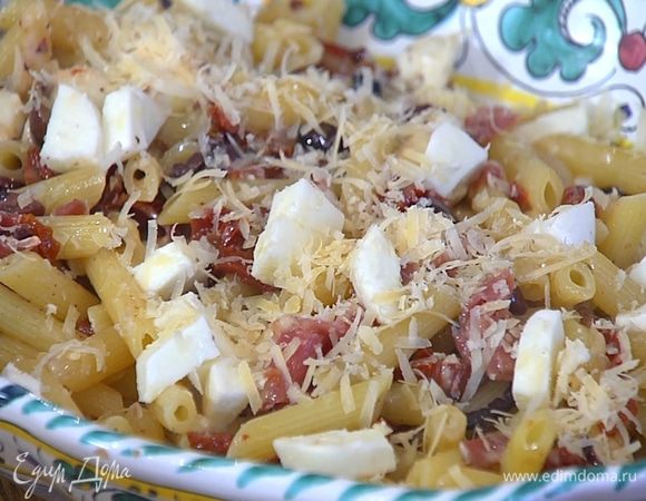 Макароны переложить в большое блюдо, посыпать оставшимся сыром и моцареллой.