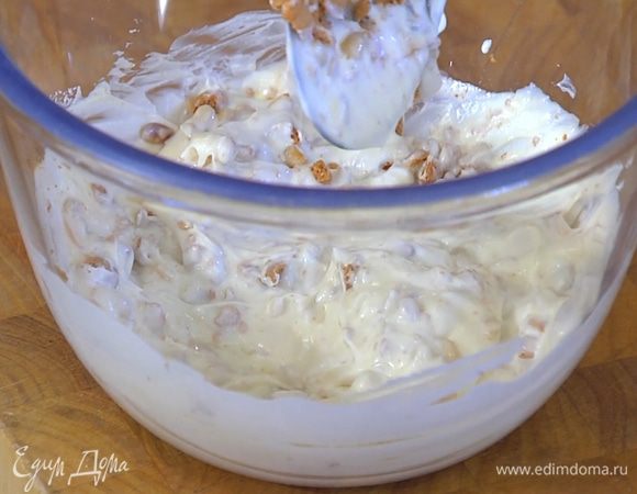 Остывшие кедровые орехи и 2/3 измельченного печенья добавить к сметане с сыром, все перемешать.