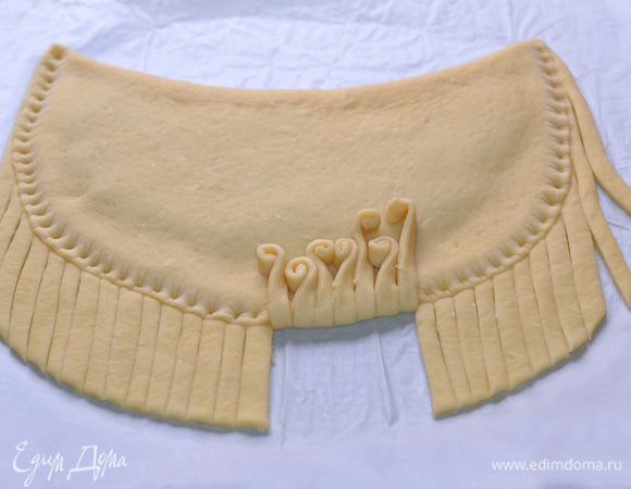 Полоски сворачивать рулетом до половины и укладывать на тесто.