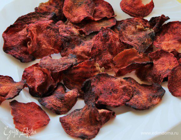 Подготовьте тарелку и выложите на нее пергаментную бумагу. На бумагу выложите небольшое количество ломтиков из свеклы и сбрызните подсолнечным маслом Олейна. Помещаем в СВЧ на полную мощность на 1 или 2 минуты. Микроволновки у всех разные, поэтому следите за процессом. А еще это зависит от толщины среза ломтиков.