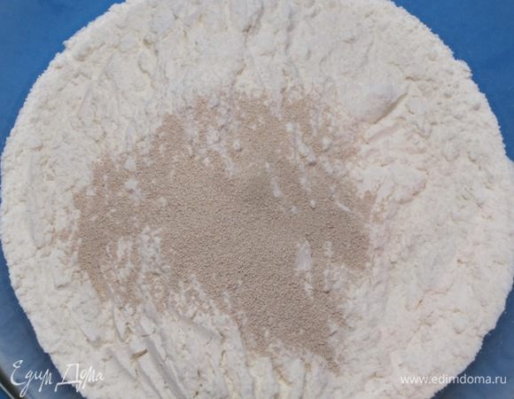 В просеянную муку всыпать сухие дрожжи.