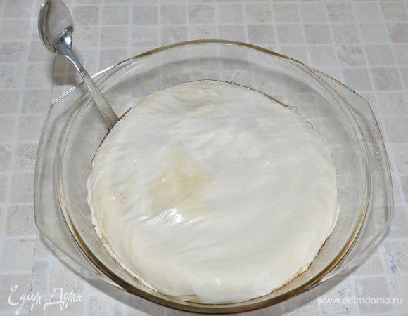 Оставшийся (седьмой) лист теста также смазать и сложить вдвое. Вырезать круг (можно прямо ножницами - тесто режется как бумага) диаметром чуть больше диаметра формы. Уложить тесто в форму и тыльной стороной ложки заправить края теста внутрь формы. 
Сделать несколько проколов зубочисткой для выхода пара. 
