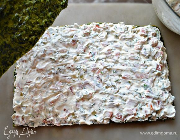 Половину начинки выложить на первый шпинатный корж, разровнять. Сверху накрыть вторым коржом, выложить оставшуюся начинку и также разровнять. 