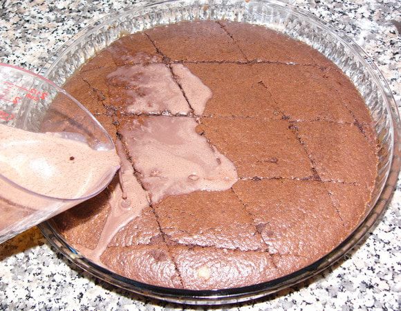 Смазываем форму маслом и выливаем тесто в форму. У моей диаметр 30 см. Если вы очень уважаете свою духовку, будьте готовы, что кекс при выпечке может увеличиться втрое. В моей, скромной, "растет" примерно в 2 раза. 
Выпекаем в разогретой духовке 25 минут. Горячий кекс нарезаем на порционные куски и заливаем пропиткой.