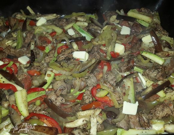 Еще минут через 10 снова перемешиваем, выкладываем по верху маленькие кусочки сливочного масла и снова отправляем в духовку